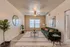 Bright and stylish living room featuring a plush green sofa, modern decor, and abundant natural light.