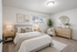 Elegant bedroom with soft neutral tones, featuring a plush bed, stylish decor, and a large mirror reflecting natural light.