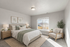 Inviting bedroom with natural light, featuring a plush bed, elegant decor, and a cozy reading nook.