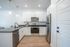 Sleek modern kitchen with stainless steel appliances, white cabinetry, and elegant pendant lighting.