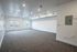Bright and spacious living area with modern recessed lighting and large windows offering natural light and a view of the outdoors.