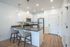 Modern kitchen with sleek countertops, stainless steel appliances, and cozy breakfast bar seating, perfect for both cooking and entertaining.