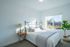 Bright and inviting bedroom with a large window, elegant bed, and stylish decor, perfect for a cozy and relaxing space.