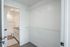 Bright walk-in closet with ample shelving adjacent to a modern bathroom featuring sleek fixtures and elegant vanity.