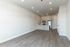 Modern open-concept living space featuring sleek kitchen with stainless steel appliances and stylish wood flooring.
