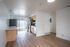 Chic apartment kitchen with modern appliances, wood flooring, and abundant natural light.