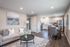 Charming open-concept living room and kitchen with modern decor, cozy seating, and sleek stainless steel appliances.