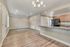 Elegant open-concept apartment featuring a modern kitchen with dark appliances, spacious living area, and stylish lighting fixtures.
