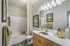Bright and modern bathroom featuring elegant lighting, sleek vanity, and tasteful decor for a luxurious feel.