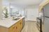 Modern kitchen with sleek stainless steel appliances, elegant light wood cabinets, and a spacious island overlooking a cozy dining area.