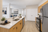 Modern kitchen with sleek stainless steel appliances, elegant light wood cabinets, and a spacious island overlooking a cozy dining area.