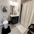 Black cabinetry & large mirror in bathroom at Incite at Troy | Off-Campus Housing in Troy, NY