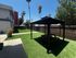 Charming outdoor space with lush green lawn, cozy picnic area, and inviting gazebos under clear blue skies.
