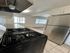Modern kitchen with sleek stainless steel fridge and stove, complemented by large, sunlit windows and elegant cabinetry.
