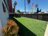 Inviting outdoor space with lush green lawn, cozy gazebo, and vibrant landscaping, perfect for relaxation and gatherings.