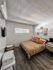 Cozy bedroom with stylish decor, featuring a comfortable bed, modern wall art, and a functional workspace.