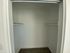 Spacious walk-in closet with sleek white shelves and modern design, perfect for organized living.