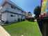 Charming apartment complex with modern architecture, lush green lawn, and inviting outdoor seating area, perfect for relaxation.