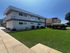 Modern apartment building with a vibrant green lawn and inviting outdoor seating area, offering a blend of comfort and style.