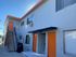 Bright, modern apartment building exterior with vibrant orange doors and a sleek metal staircase, promising contemporary urban living.