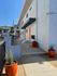 Modern apartment exterior with sleek gray facade, vibrant orange doors, and stylish potted plants, offering a welcoming and urban vibe.