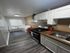 Modern apartment kitchen with sleek countertops, white cabinetry, and cozy dining nook with natural light.