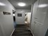 Inviting hallway with sleek hardwood floors and ample storage, leading to a cozy bedroom and vibrant bathroom.