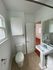 Charming bathroom with a classic pedestal sink, bright window lighting, and elegant tiled flooring.