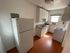 Bright and cozy kitchen featuring sleek white cabinetry, modern appliances, and natural light from a sunny window.