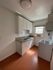Bright, cozy kitchen with modern white cabinetry, sleek countertops, and warm hardwood floors.
