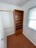Bright walk-in closet featuring elegant wooden shelving and dual hanging rods, offering ample storage space.