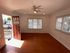 Inviting living room with hardwood floors, abundant natural light, and a charming ceiling fan, welcoming you to a cozy atmosphere.