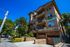 Charming multi-story apartment building with inviting balconies and lush greenery in a vibrant neighborhood.