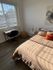 Bright bedroom with elegant decor, cozy bed with plush pillows, and a serene work desk by the window.