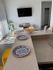Bright and modern kitchen with elegant marble countertops, accented by vibrant blue-patterned plates and a bowl of fresh lemons, creating a welcoming atmosphere.