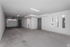 Spacious and versatile garage interior with modern lighting and a laundry area, ideal for storage or creative use.