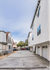 Charming urban apartment complex with spacious driveways, modern facades, and ample natural light.