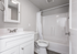 Modern bathroom with sleek white vanity, stylish fixtures, and a pristine shower area, offering a fresh and elegant ambiance.
