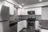Modern kitchen with sleek stainless steel appliances, elegant white cabinetry, and stylish mosaic tile backsplash.