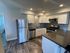 Modern kitchen with sleek stainless steel appliances, polished countertops, and mosaic tile backsplash, creating an elegant cooking space.