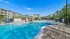 Inviting resort-style pool area with sparkling water, surrounded by elegant apartment buildings and lush greenery, perfect for relaxation and sunny days.