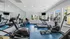 Modern fitness center with state-of-the-art exercise equipment, sleek mirrors, and abundant natural light streaming through large windows.