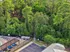 Charming aerial view of a lush green forest adjacent to a poolside lounge area with a cozy outdoor setup, perfect for relaxation and recreation.