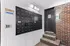 Modern apartment entry featuring a stylish mailroom with sleek black mailboxes and illuminated brick staircase, creating a chic and secure environment.