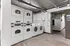Modern laundry room with stacked washers and dryers, featuring a sleek industrial design and ample space for efficient laundry tasks.