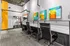 Chic coworking space with modern black office chairs, vibrant abstract art, and a stylish industrial design.