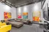 Contemporary living room featuring vibrant abstract artwork, plush sectional sofa with colorful cushions, and modern lighting.