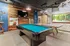 Chic entertainment room with pool table, stylish wooden accents, and vibrant artwork offering a trendy urban vibe.