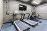 Modern fitness room featuring state-of-the-art treadmills and a stationary bike with a sleek wall-mounted TV.
