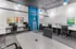 Modern coworking space with sleek black chairs, vibrant artwork, and stylish white desks, offering a creative and productive environment.
